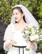 关晓彤立于窗前光影中，缎面婚纱勾勒出优雅身形轮廓