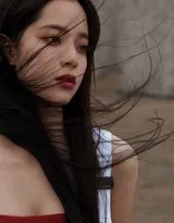 她手提宝箱行走于石林小径，裙摆随风轻扬，背景是亿万年前形成的喀斯特地貌，构成一幅动静相宜的探索画卷