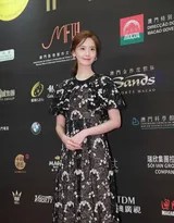 林允儿在活动现场向粉丝比出爱心手势，笑容灿烂如花，黑色裙摆轻舞，瞬间温暖了整个空间