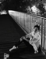 肖战背对镜头凭栏而立，黑色外套与夜幕融为一体，桥下车灯划出流动的光轨，构成一幅孤独又温柔的城市画卷