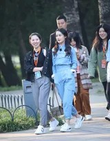 李沁推开朱红木门转身展颜，门缝透出的光晕染蓝工装