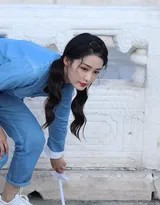 李沁仰首观察藻井彩画，工装背影与斗拱构成几何之美