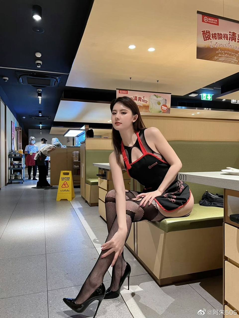 镜头特写展示当事人化着浓妆，神情暧昧地望向餐桌
