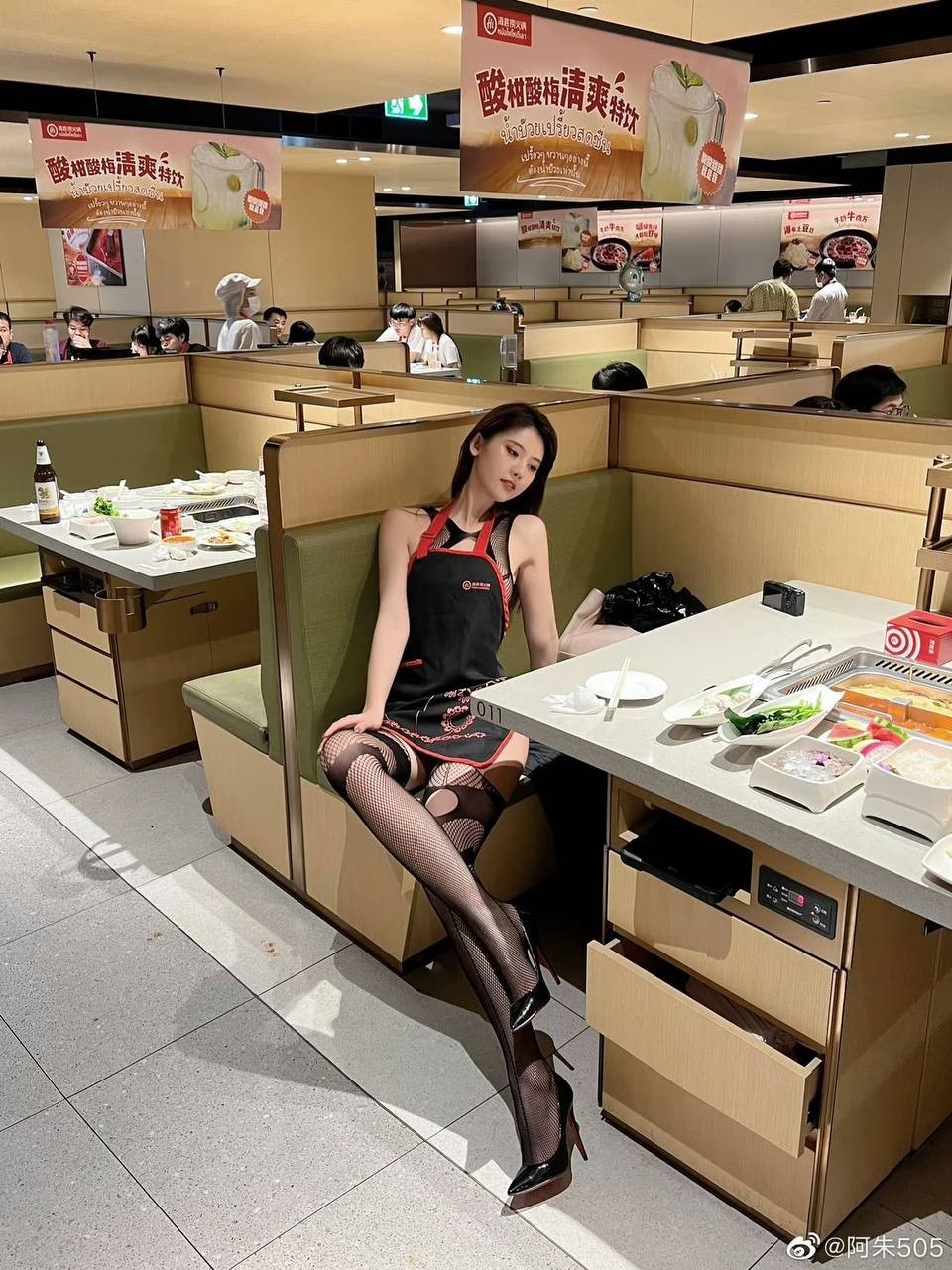 画面捕捉到当事人脱去外套的瞬间，背景清晰可见海底捞的用餐环境