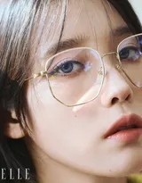 她倚靠旧木桌旁，柔和光线与针织纹理交织出温暖的秋季质感