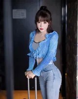 暖色氛圍燈下，模特雙腿交疊斜坐，一手自然垂放，光影在緊身褲上勾勒出曼妙臀腿曲線