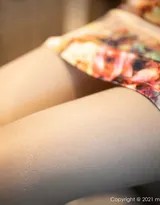 特写镜头捕捉绮里嘉的精致侧颜，她指尖轻抚过蕾丝覆盖的锁骨，睫毛在光影下根根分明，唇角含着一丝若有若无的笑意