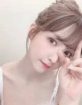 柔和光线下，她倚靠角落，毛绒吊带衬出温柔气质，一抹恬静微笑与松软丸子头共同渲染出宁静氛围