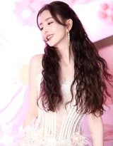 佟丽娅展露灿烂笑颜，阳光洒落肩头发梢，宛若春日暖阳化身