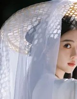李凯馨手持长箫静立湖畔，侧颜温柔，白衣与黑发在微风轻拂下更显飘逸出尘。