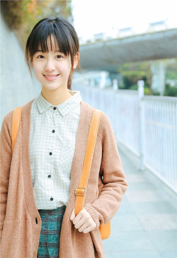 白衣少女手执书卷静立长廊 光影交错间宛若文艺电影定格