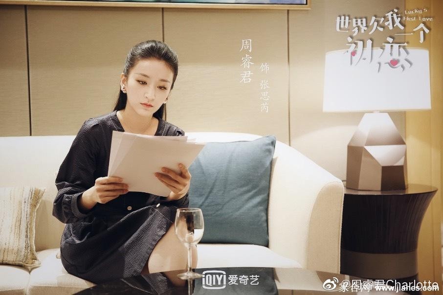 周睿君身着黑色短裙侧坐，腿部曲线在光影下宛若艺术品