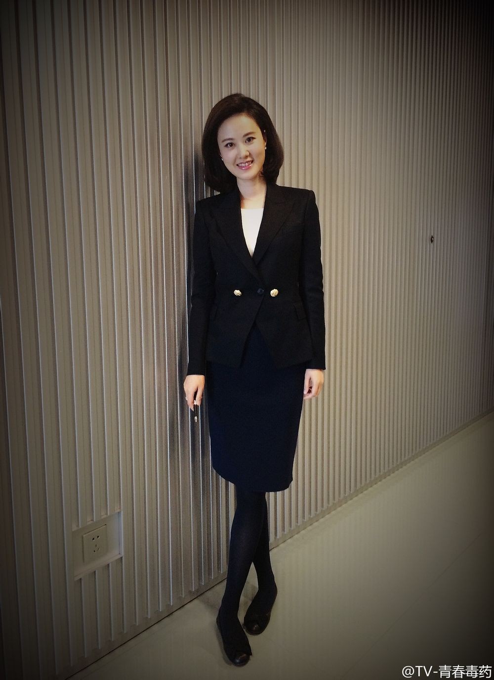 秦方身穿剪裁精良的西装外套与一步裙，全身照尽显其高挑身材与优雅干练的职业风范