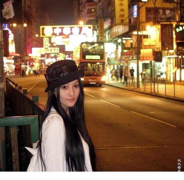 张馨予身穿白色蕾丝礼服半躺羽毛丛中，仰头展露清晰下颌线