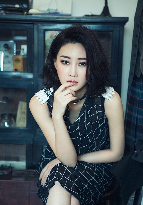 一袭粉白长裙的林鹏蜷坐于沙发，慵懒惬意如春日午后猫咪