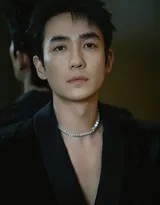 朱一龙身着经典黑色西装，身姿挺拔凝视镜头，目光深邃如炬