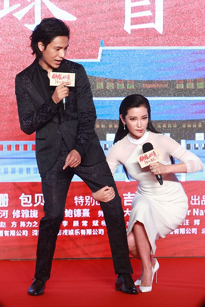 李冰冰站立于聚光灯下，闪钻装饰的礼服如星河披身，她笑容明亮自信，彰显国际巨星的无畏气场。
