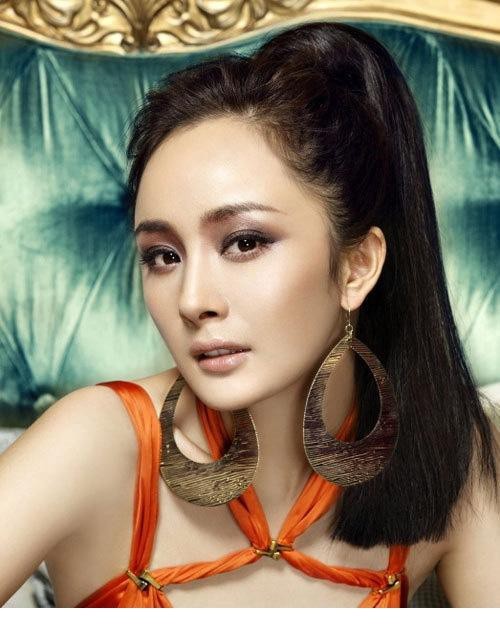杨幂一袭黑色透视薄纱长裙侧身回眸，身姿曲线在朦胧光影中尽显神秘与优雅