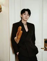 王俊凯低头审视法棍，西服领口细节精致