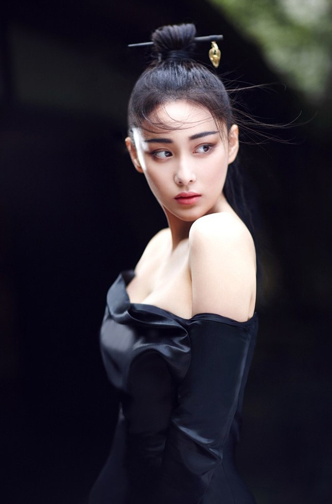 张馨予手持团扇半遮面，眼波流转间尽显东方美人含蓄风韵