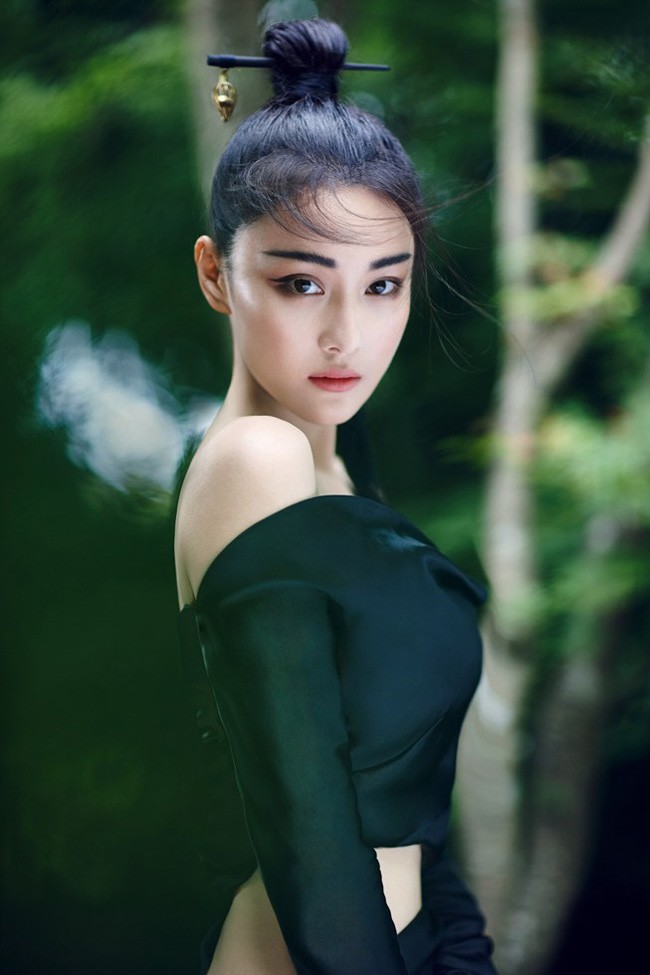 张馨予轻倚朱红窗棂浅笑嫣然，古典裙裾与静谧庭院相映成趣