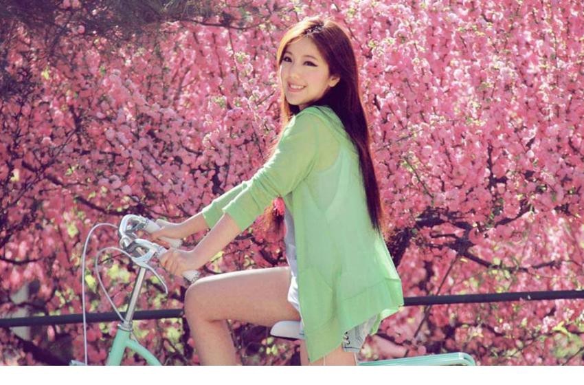赵奕欢展露灿烂笑颜倚靠单车，明媚笑容如春日暖阳般治愈人心