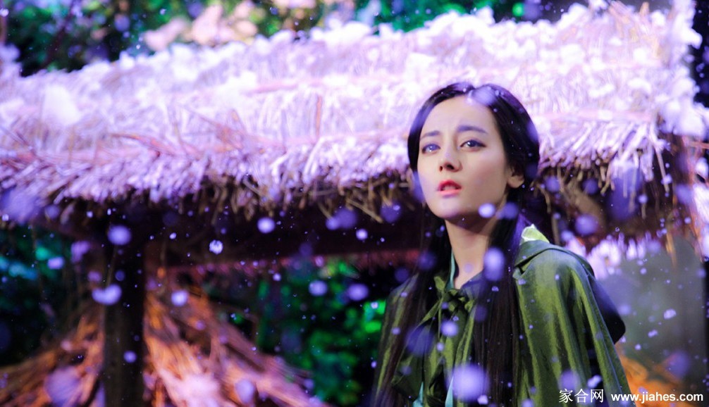 迪丽热巴在柔和光线下露出恬静侧颜，卷发蓬松，营造出宛如古典油画般的静谧氛围