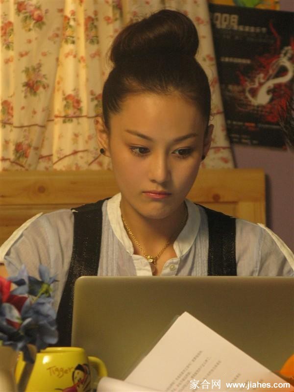阳光下绽放灿烂笑容，张馨予倚靠场景道具，尽显少女时代的俏皮与活力