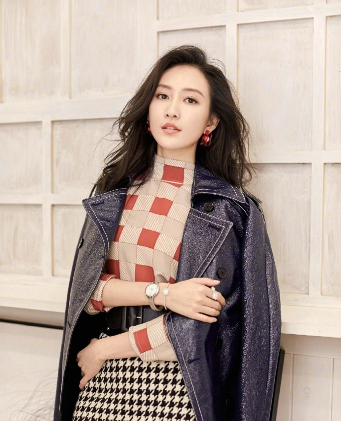王鸥一袭红裙倚靠窗边，明媚色彩与优雅曲线勾勒出万种风情