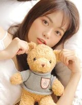 女孩伸展身体布偶熊陪伴，放松姿态中透出青春活力