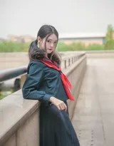 少女在河边侧身自拍，制服与流水相映，倒影中透出宁静之美
