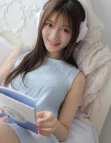 柔和的光线穿过薄纱窗帘，女孩环抱双膝坐在床角，微笑中带着初醒的懵懂与恬静，如同日系电影中的一帧。