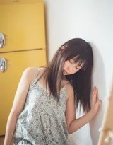 特写镜头下，少女轻咬下唇露出羞涩笑意，碎花吊带的蕾丝边衬得肌肤雪白