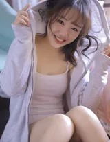 甜美微笑面对镜头，粉嫩妆容与白色服装相映成趣