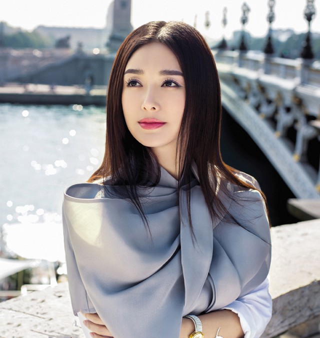 秦岚身穿黑色修身西装漫步于巴黎小巷，手中咖啡杯与石板路构成生活化时尚场景