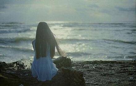 古镇湿漉石阶上撑伞女子的朦胧背影，细雨薄雾如思绪般绵延不绝