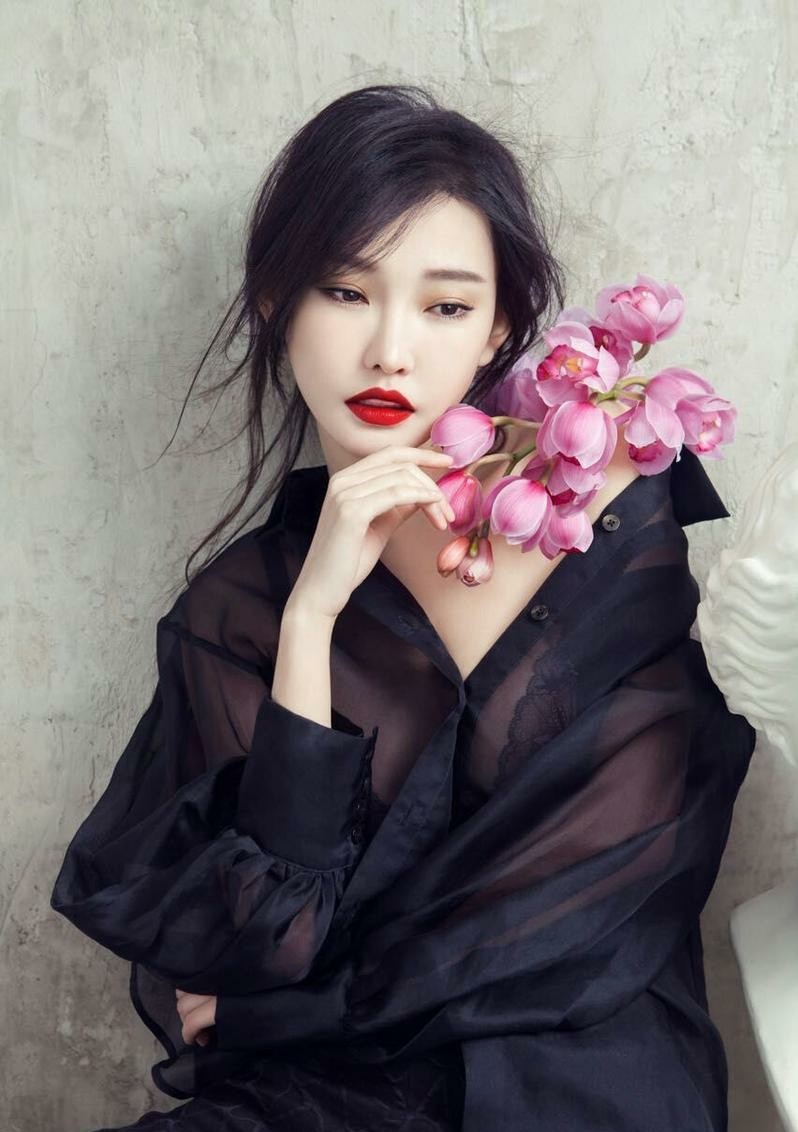 特写镜头聚焦童菲精致面部与烈焰红唇，眼眸低垂间诉说无尽故事