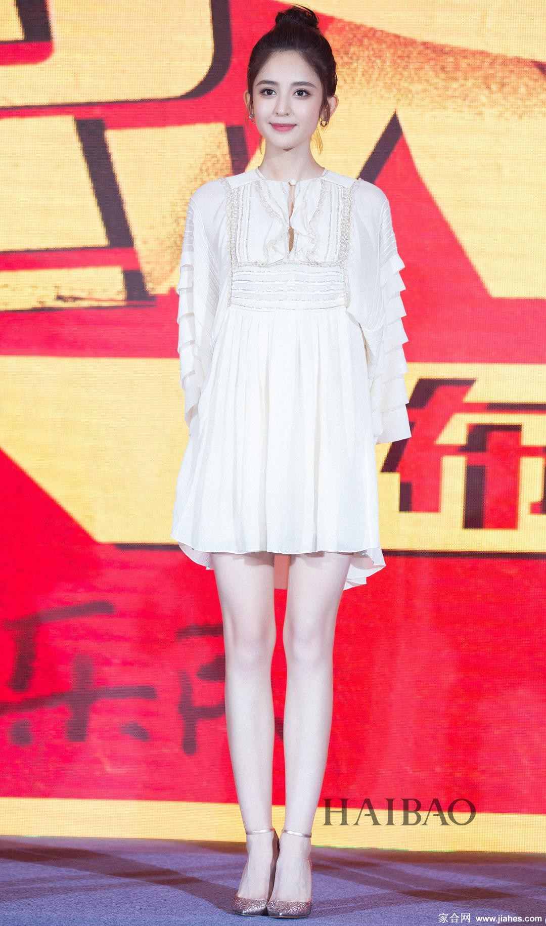 古力娜扎侧身站立，一袭修身长裙勾勒出流畅的腿部线条，光影在其小腿处形成一道优雅的高光，宛如玉石雕塑。