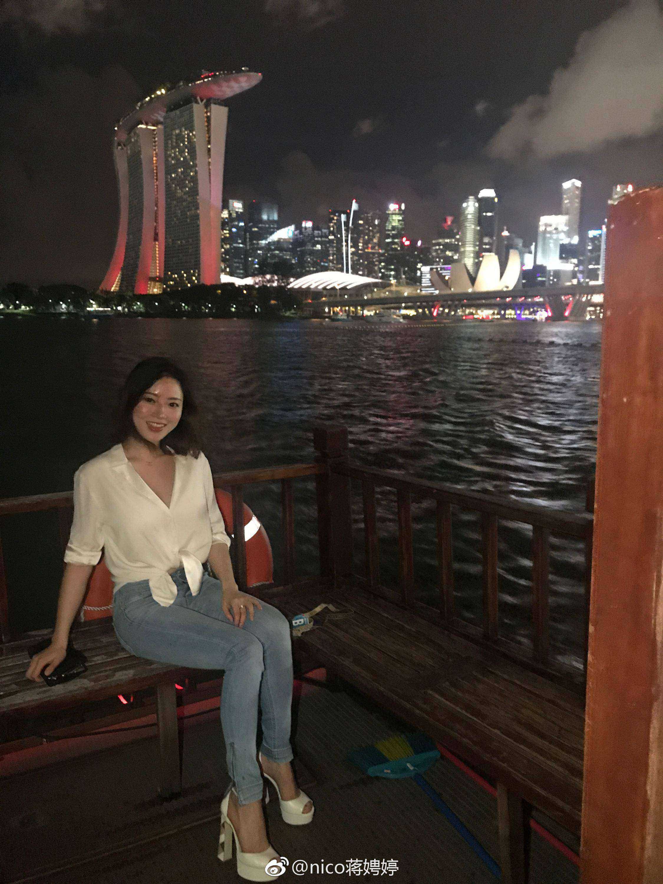 身着黑色紧身运动装的女性在健身房内，对镜自拍展现健美身材曲线