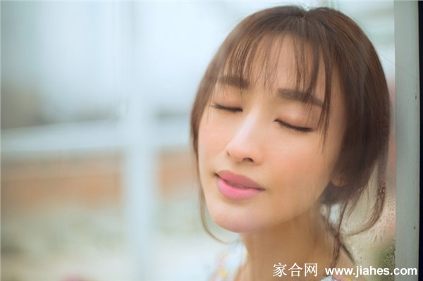 张俪侧首轻嗅花朵，长睫毛在阳光下投下淡淡影子，画面静谧而美好
