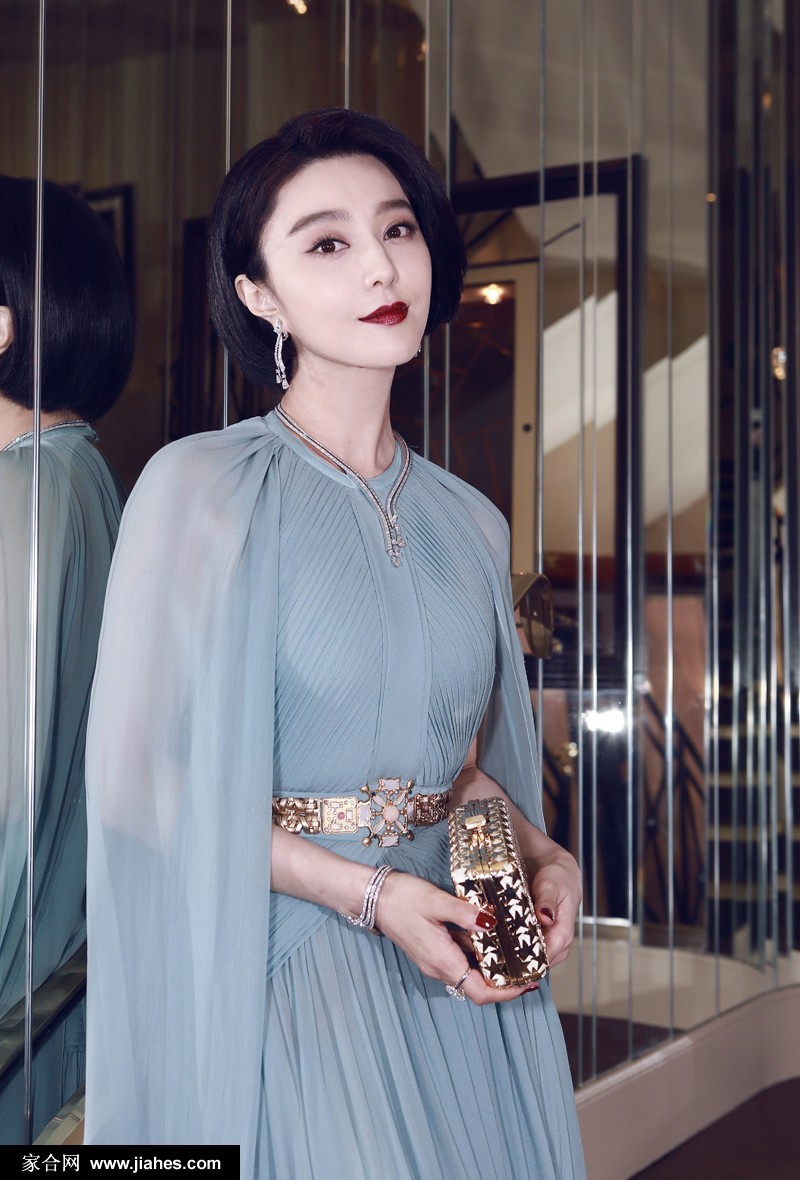 范冰冰身着华服优雅站立，灯光下礼服裙摆如星河倾泻