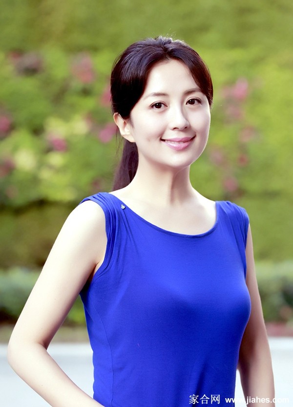 杨童舒倚靠窗边，自然光勾勒出曼妙身姿曲线，丝袜微光闪烁，尽显腿部优美线条与细腻质感