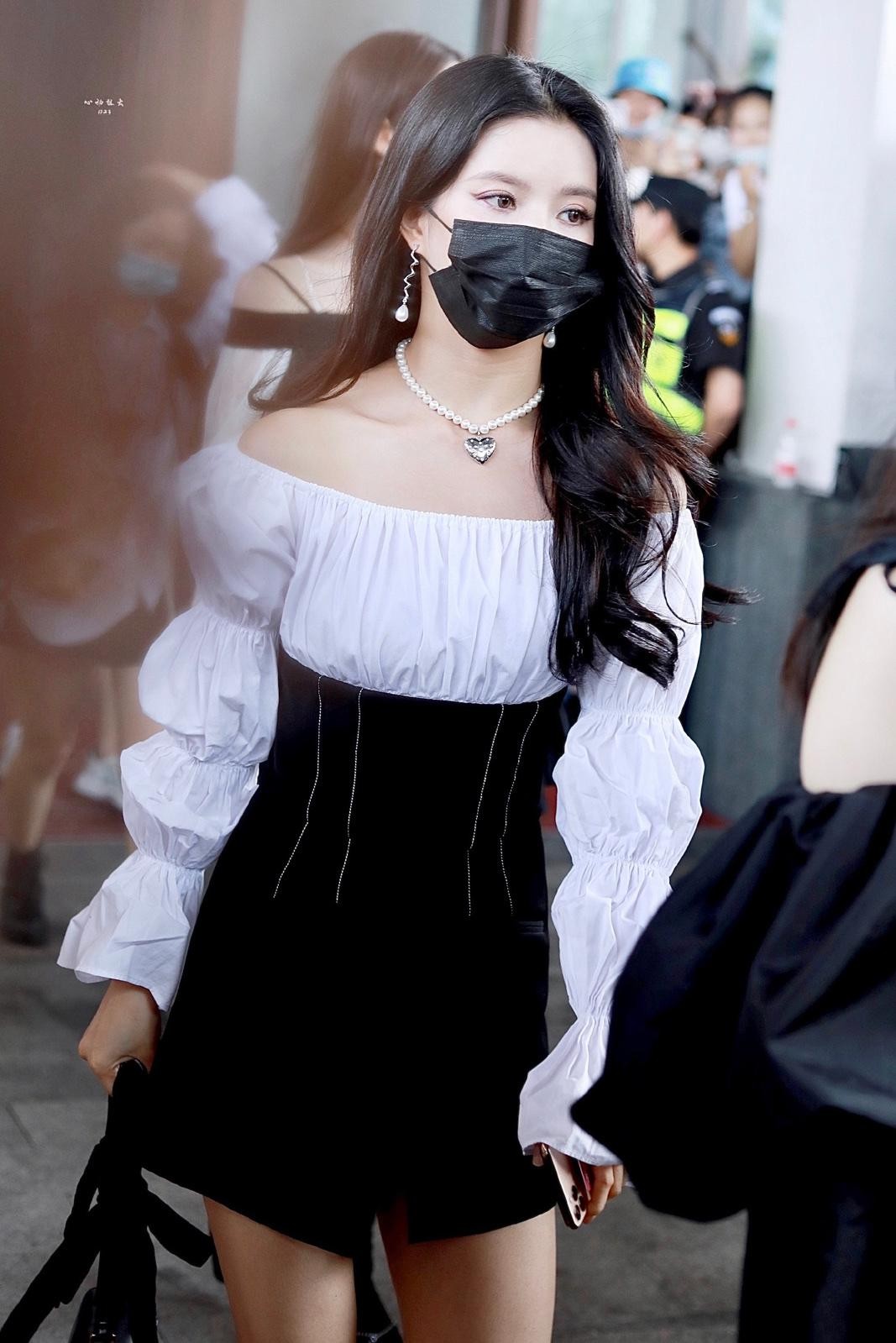 刘些宁背靠现代建筑幕墙，光影勾勒其精致侧颜与柔美肩颈线条