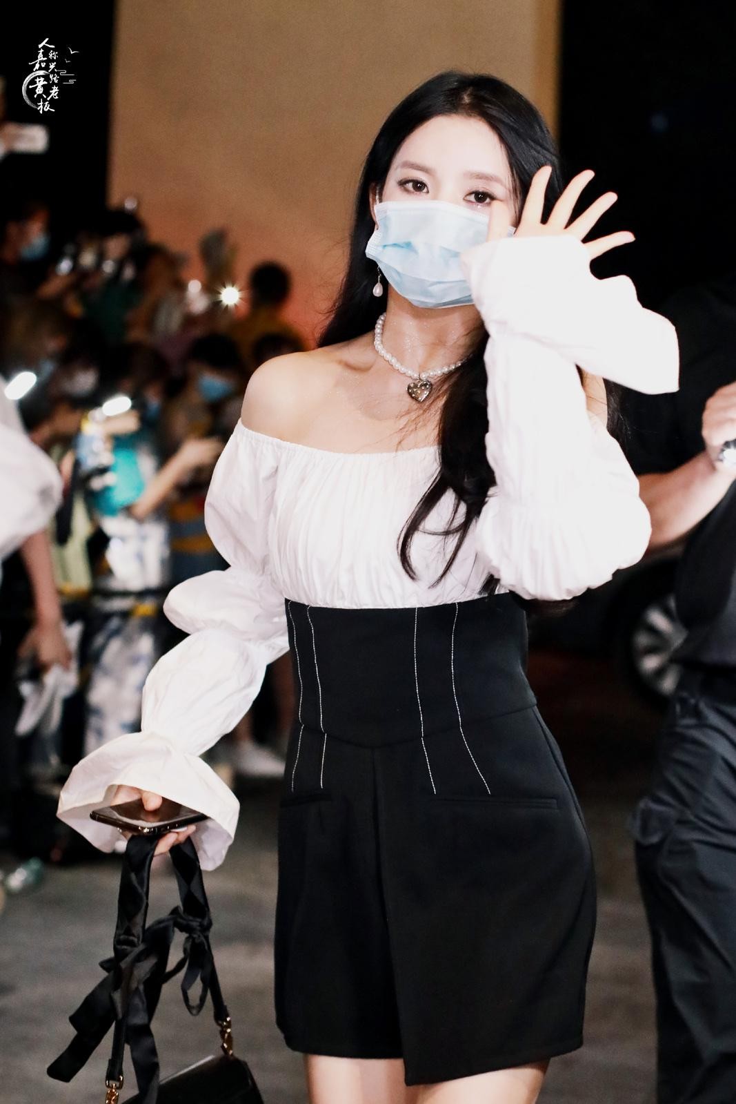 斑马线前光影交错，刘些宁身着紧身裙从容伫立，展现摩登都会女郎风范