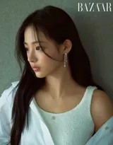 金玟池指尖轻触钻石项链，低垂眼帘间流转着静谧沉思，颈间流光如星河倾泻