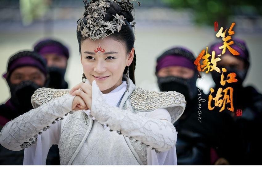 袁姗姗手持短笛侧身回眸，月光洒落肩头，银白衣裙宛如流水倾泻，勾勒出侠女亦柔亦刚的独特韵味