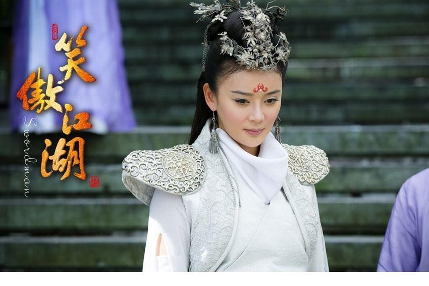 圣姑任盈盈执剑遥望，身后云雾缭绕，银白战衣熠熠生辉，展现了武林巅峰女子那份从容与磅礴气度