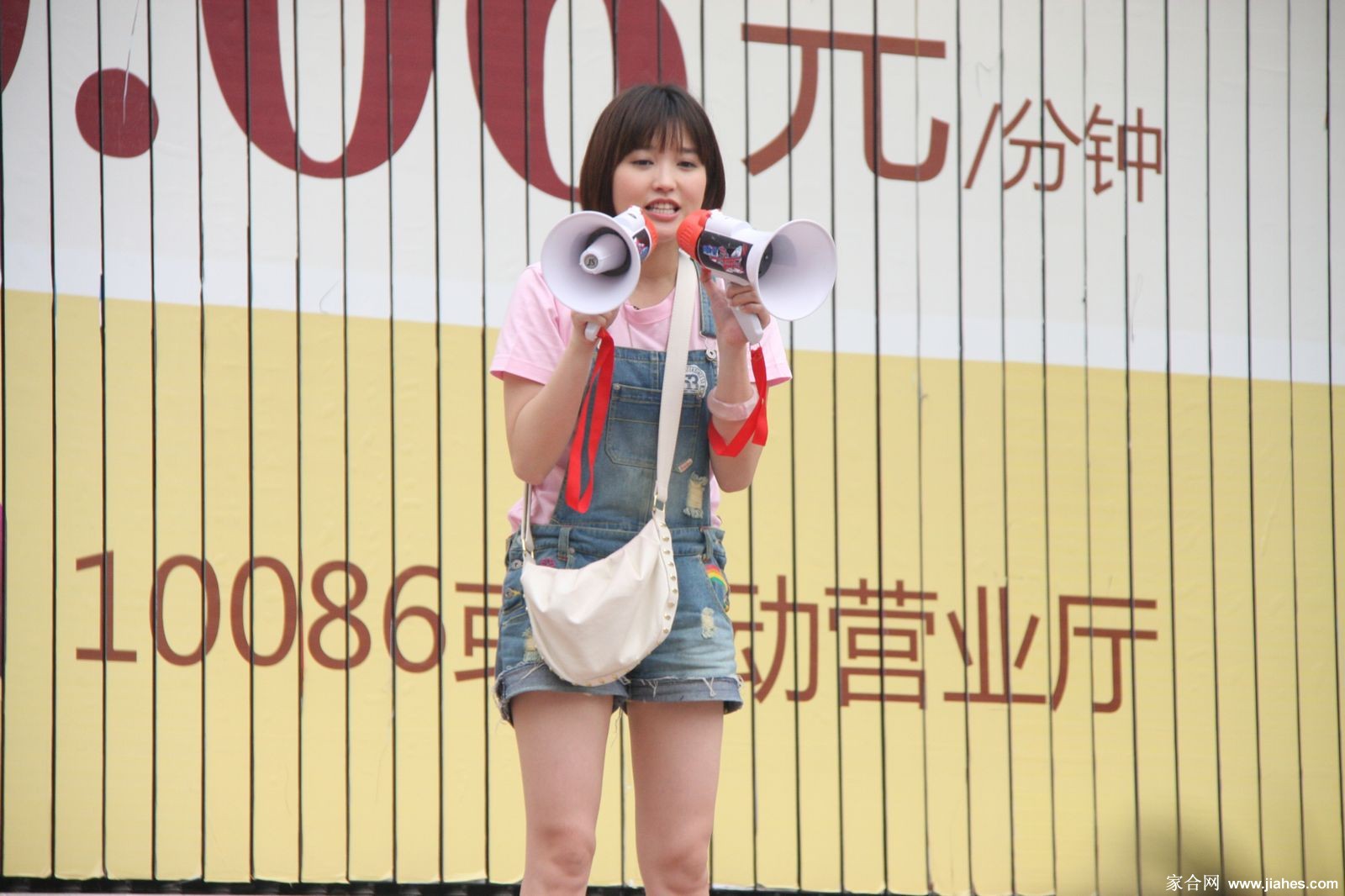 金莎于聚光灯下凝神演唱，身着闪亮舞台装，肢体语言丰富，尽显专业歌手沉浸于音乐世界的动人时刻