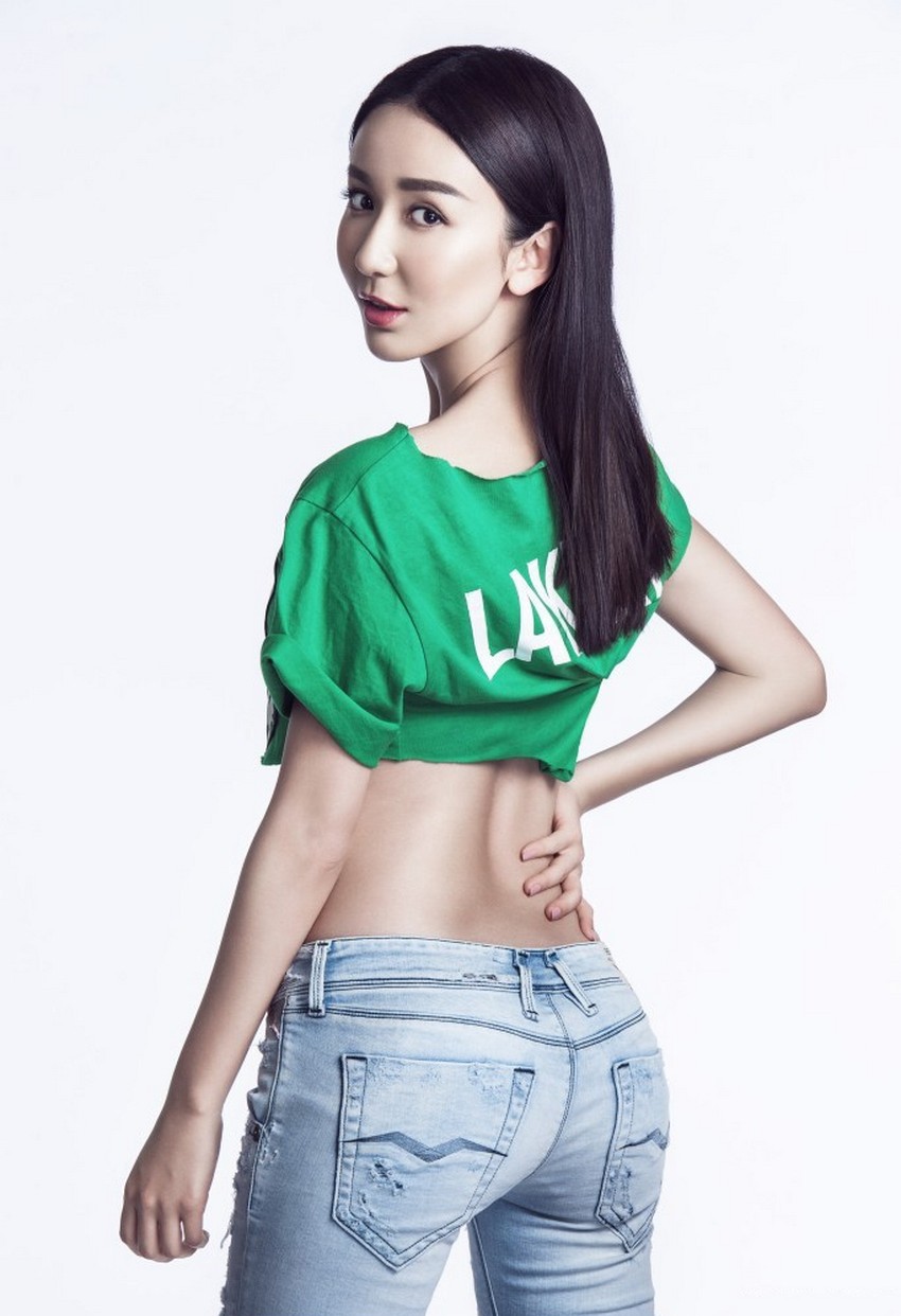 娄艺潇侧身凝视镜头，黑色露脐上衣勾勒出曼妙腰线，时尚动感气息扑面而来