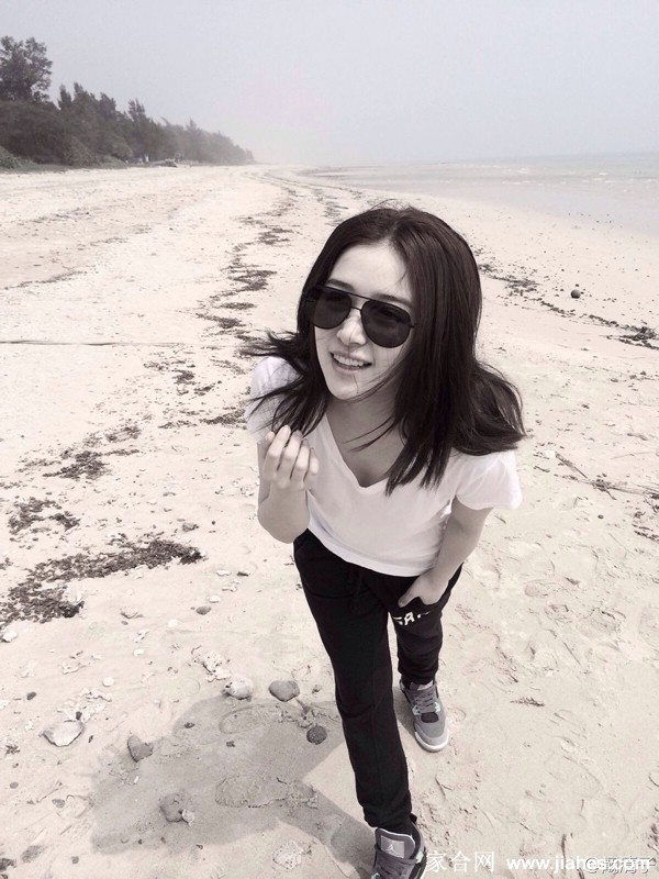 阚清子身着蓝色碎花长裙侧身回望，海风轻拂发丝，笑容静谧而治愈